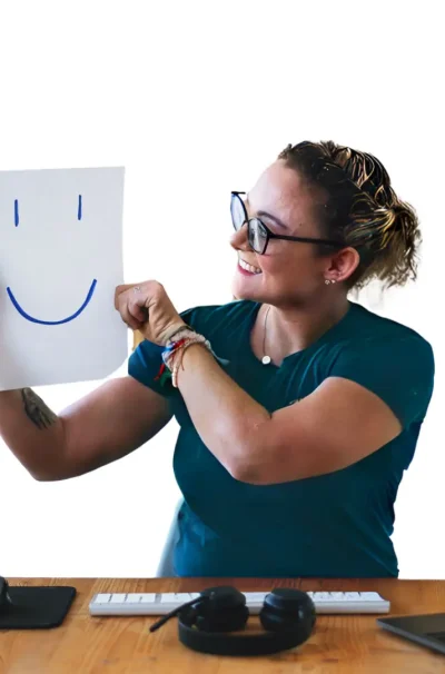 Happy Career Coaching - Sandra hält lächelnd ein Smiley-Schild hoch, motivierendes Bewerbungscoaching